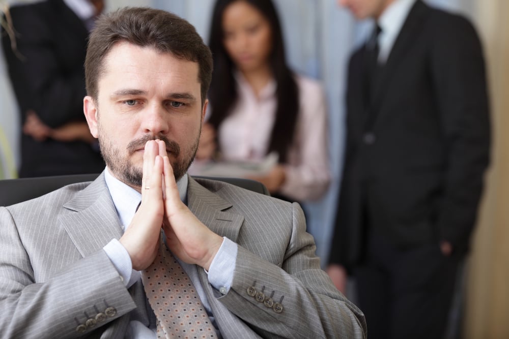 Portrait of a worried businessman with his team working behind