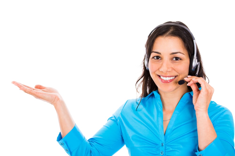 Portrait of happy smiling cheerful customer support phone operator in headset pointing at something, over white background